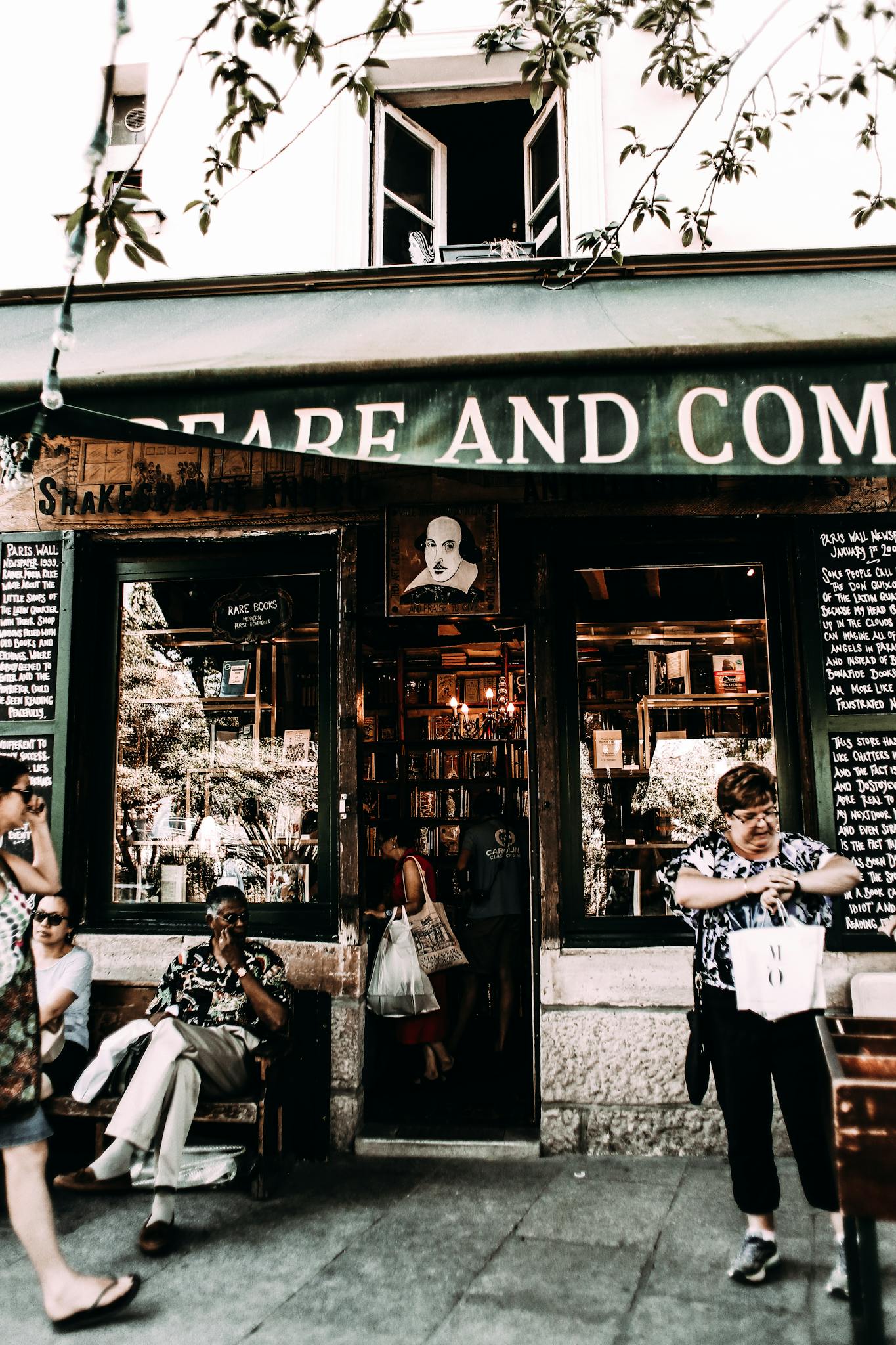 Multiethnic people near entrance of old shop with glass cases in city at daytime